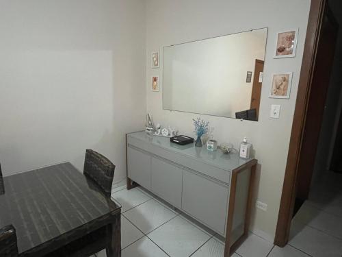a room with a dresser with a mirror on the wall at Praia das Astúrias - WI-FI e AR CONDICIONADO NOS QUARTOS in Guarujá