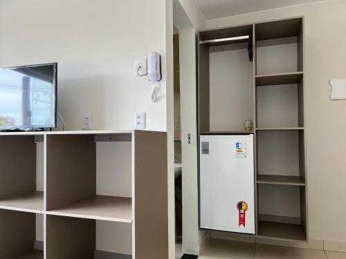 a kitchen with a white refrigerator and shelves at Sobradinho Hotel in Sobradinho