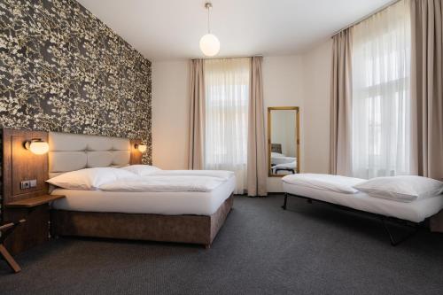 a hotel room with two beds and a mirror at EA Hotel Victoria in Prague
