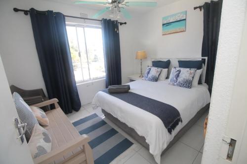 Un dormitorio con una cama grande y una ventana en Laguna La Crete 12, en Uvongo Beach