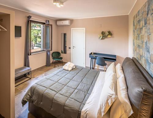 1 dormitorio con cama, sofá y escritorio en Casa Corsetti - Locanda e Ristorante, en Magione