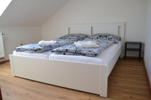 a white bed with two pillows on top of it at Apartmán Benešovka in Vacov