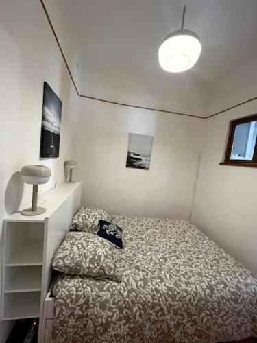 um pequeno quarto com uma cama e um candeeiro em Le Pêcheur em Cassis