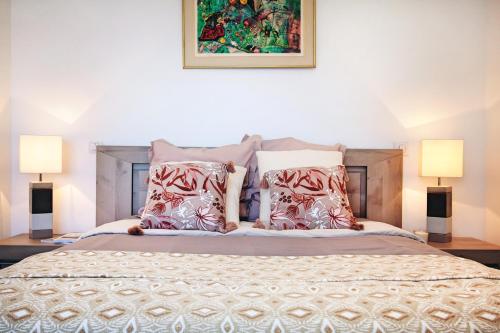 a bedroom with a bed with pillows and two lamps at Résidence de la Tour in Piana