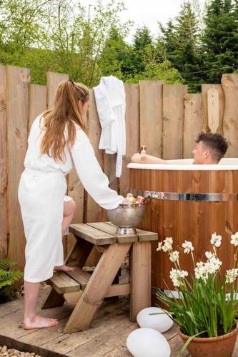 a woman giving a man a bath in a bath tub at The Rumple Hut in Wingfield