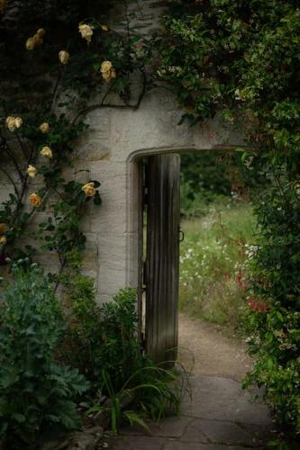 a door in the side of a building with flowers at The Rumple Hut in Wingfield