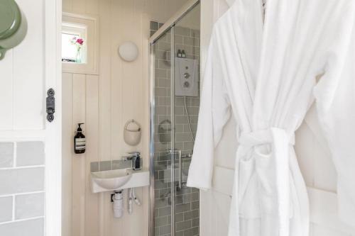 a white bathroom with a sink and a shower at The Rumple Hut in Wingfield