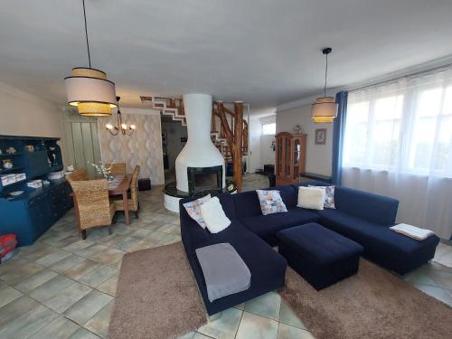 uma sala de estar com um sofá azul e uma lareira em Bajcsyház Apartman em Keszthely