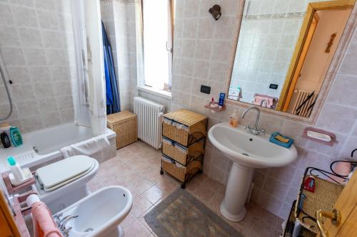 een badkamer met een wastafel, een toilet en een spiegel bij Casa vacanze “Le noci” in SantʼEufemia a Maiella