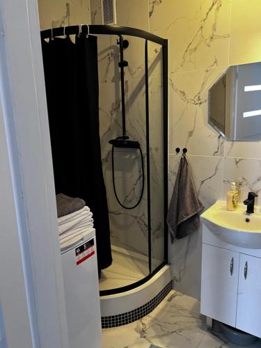 een douche met een zwart douchegordijn in de badkamer bij Apartament 33 in Bełchatów