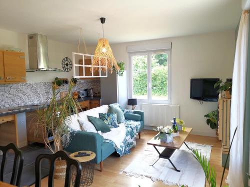 a living room with a couch and a table at Comme une Envie d'air FORET in Guémy