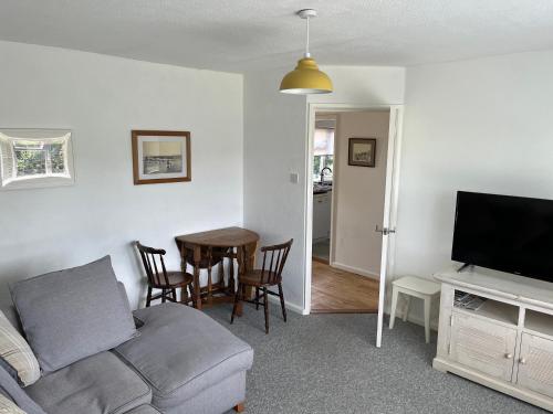 a living room with a couch and a table at Spacious one bed apartment in a quiet leafy close. in Barnstaple