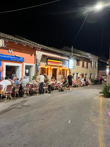 a group of people sitting in chairs on a street at night at Villa Alexakis Doukades in Doukádes