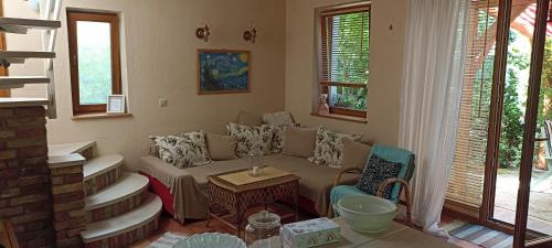 a living room with a couch and a table at Barackvirág Apartmanház in Vonyarcvashegy