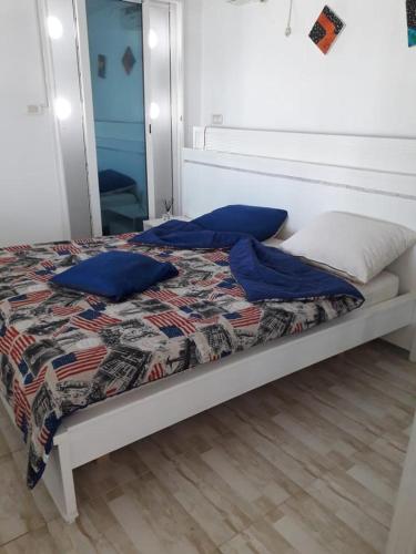 a bedroom with a bed with blue pillows and a mirror at Monastir cap Marina in Monastir