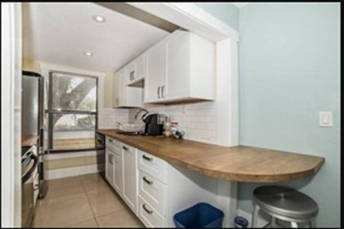 a kitchen with white cabinets and a wooden counter top at St Petersburg Vacation Rentals in St Petersburg