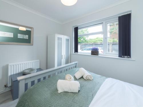 a bedroom with a bed with towels on it at Pass the Keys 2BDR Peaceful Ground Floor Apartment Free Parking in Wokingham