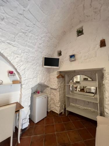 a room with a stone wall with a tv on the wall at Casa Il Rosone in Carovigno