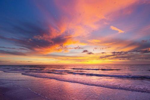 a sunset on a beach with the ocean at St Petersburg Vacation Rentals in St Petersburg