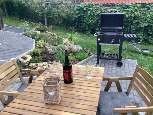 a bottle of wine sitting on a wooden table with a grill at Vulcanus Apartment in Badacsonytomaj