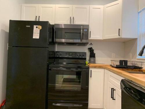 a kitchen with a black refrigerator and a microwave at St Petersburg Vacation Rentals in St Petersburg
