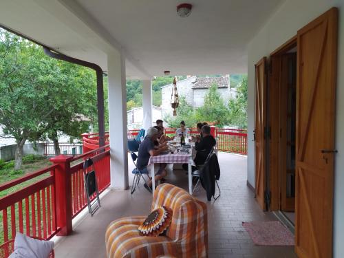 a group of people sitting at a table on a porch at Casa BnB Pappappero Monti della Laga in Fioli