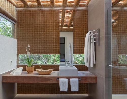 een badkamer met een wastafel en een spiegel bij Capim do Mato Pousada & Spa by L'Occitane in Serra do Cipo