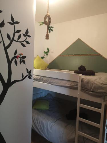 a bedroom with a bunk bed with a tree decal on the wall at Comme une Envie d'air FORET in Guémy