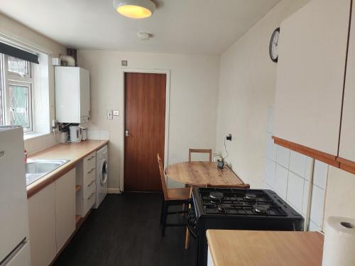 a kitchen with a stove and a table in it at A&A Luxury Stay Noble Street in Sunderland