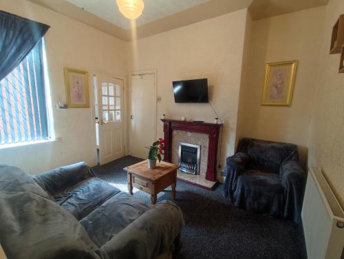 a living room with a couch and a fireplace at A&A Luxury Stay Noble Street in Sunderland