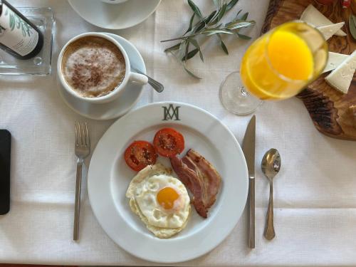 a table with a plate of breakfast food and a cup of coffee at Hotel Boutique Molino del Arco in Ronda