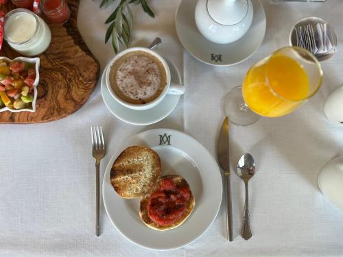 a table with a plate of breakfast food and a cup of coffee at Hotel Boutique Molino del Arco in Ronda