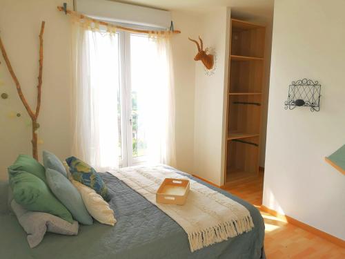 a bedroom with a large bed with a window at Comme une Envie d'air FORET in Guémy