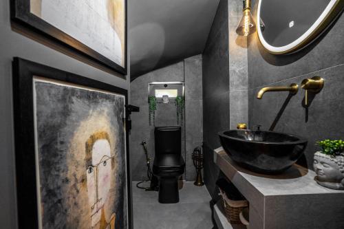 uma casa de banho com um lavatório e um WC. em Theros Luxury Boutique Villa em Anavissos