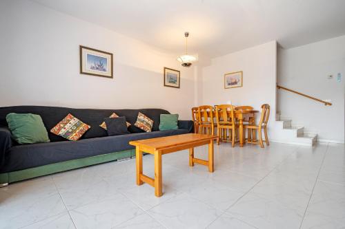 a living room with a couch and a table and chairs at Hauzify I Casa Arboç in Platja  d'Aro