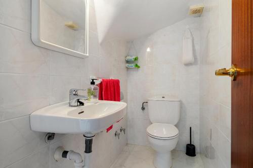 a white bathroom with a sink and a toilet at Hauzify I Casa Arboç in Platja  d'Aro