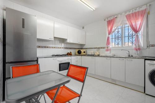 a kitchen with orange chairs and a table in it at Hauzify I Casa Arboç in Platja  d'Aro
