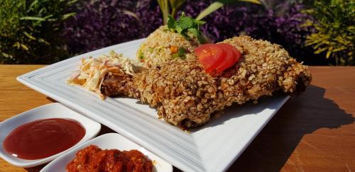 a plate of food with rice and sauce on a table at Lemon Beach Resort in Elmina