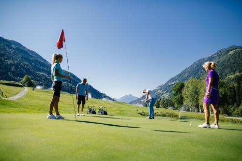 a group of people playing golf on a golf course at Andreus Resorts in San Leonardo in Passiria