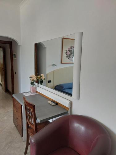 a bedroom with a desk and a bed with a mirror at Hotel Klein Wien in Piano di Sorrento