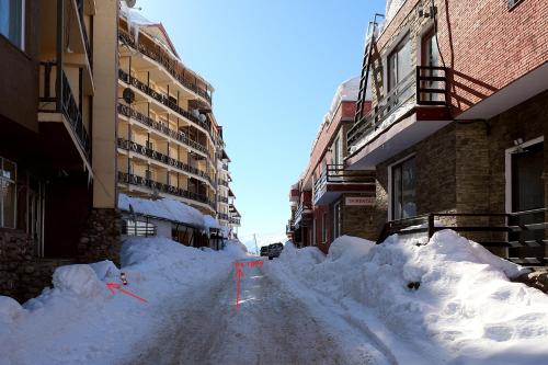 a street covered in snow next to some buildings at 2-room Apartment Gudauri Penta 303 in Gudauri