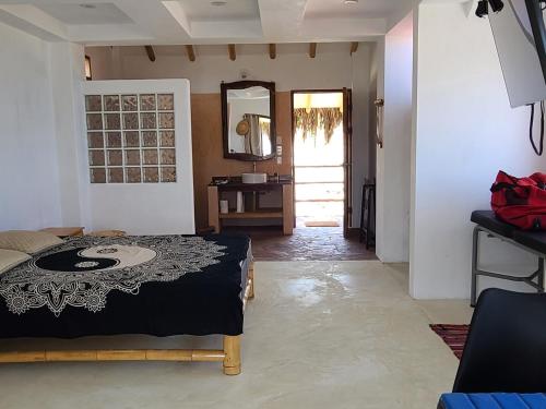 a bedroom with a bed and a table and a mirror at Bungalow Villa Alive in Los Órganos