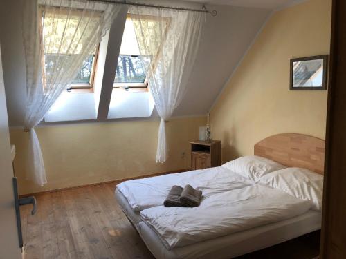 1 dormitorio con 1 cama blanca y 2 ventanas en Krissun, en Pobierowo