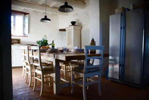 uma cozinha com uma mesa com cadeiras e um frigorífico em Lovely Country House em Fontignano