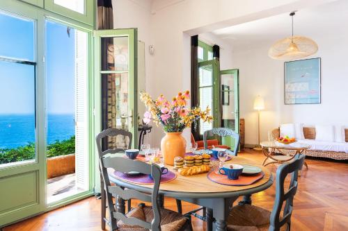 une salle à manger avec une table avec un vase de fleurs dans l'établissement Villa Reve d azur vi4353 by Riviera Holiday Homes, à Nice