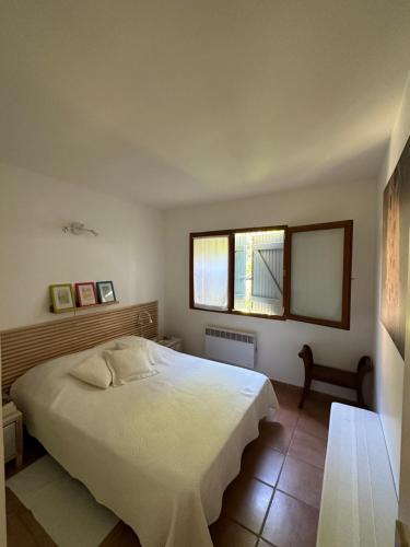 a bedroom with a white bed and a window at Appartement des Lices in Saint-Tropez