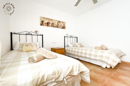 two beds in a room with white walls at Villa Privilege Sun in Corralejo