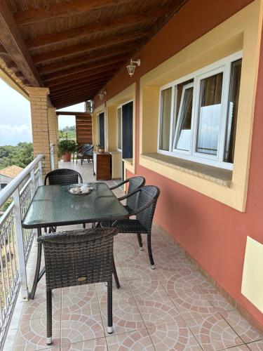 a patio with chairs and tables on a balcony at Village House Kalypso in Paleokastritsa