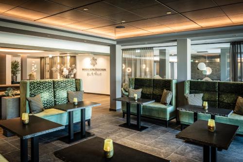 a restaurant with couches and tables and chairs at Moselschlösschen Spa & Resort in Traben-Trarbach