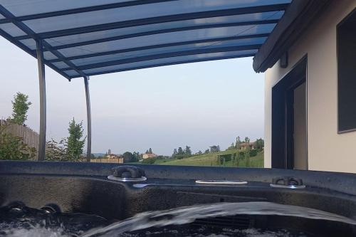 bañera de hidromasaje con toldo azul junto a una ventana en Villa Ginkgo-955 avec SPA privatif en Albi
